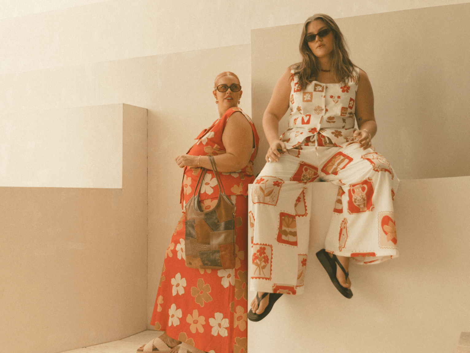 Three women wearing linen printed sets, relaxed sitting on stairs outside in a fashionable manner