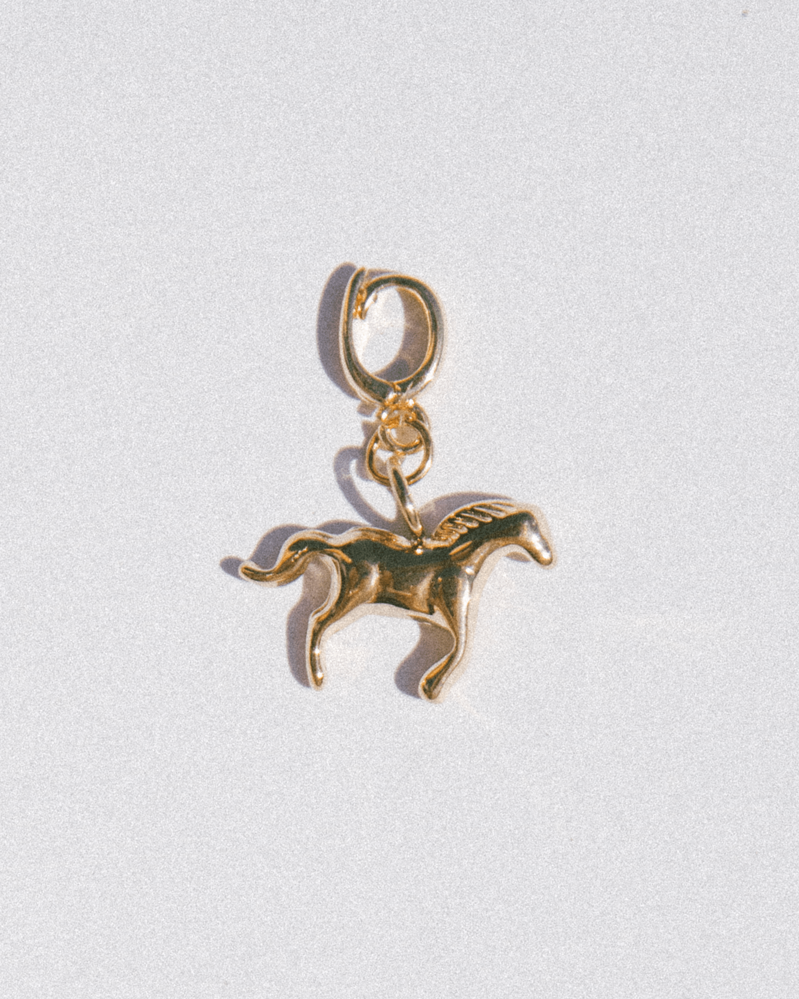 Gold horse charm on a white background