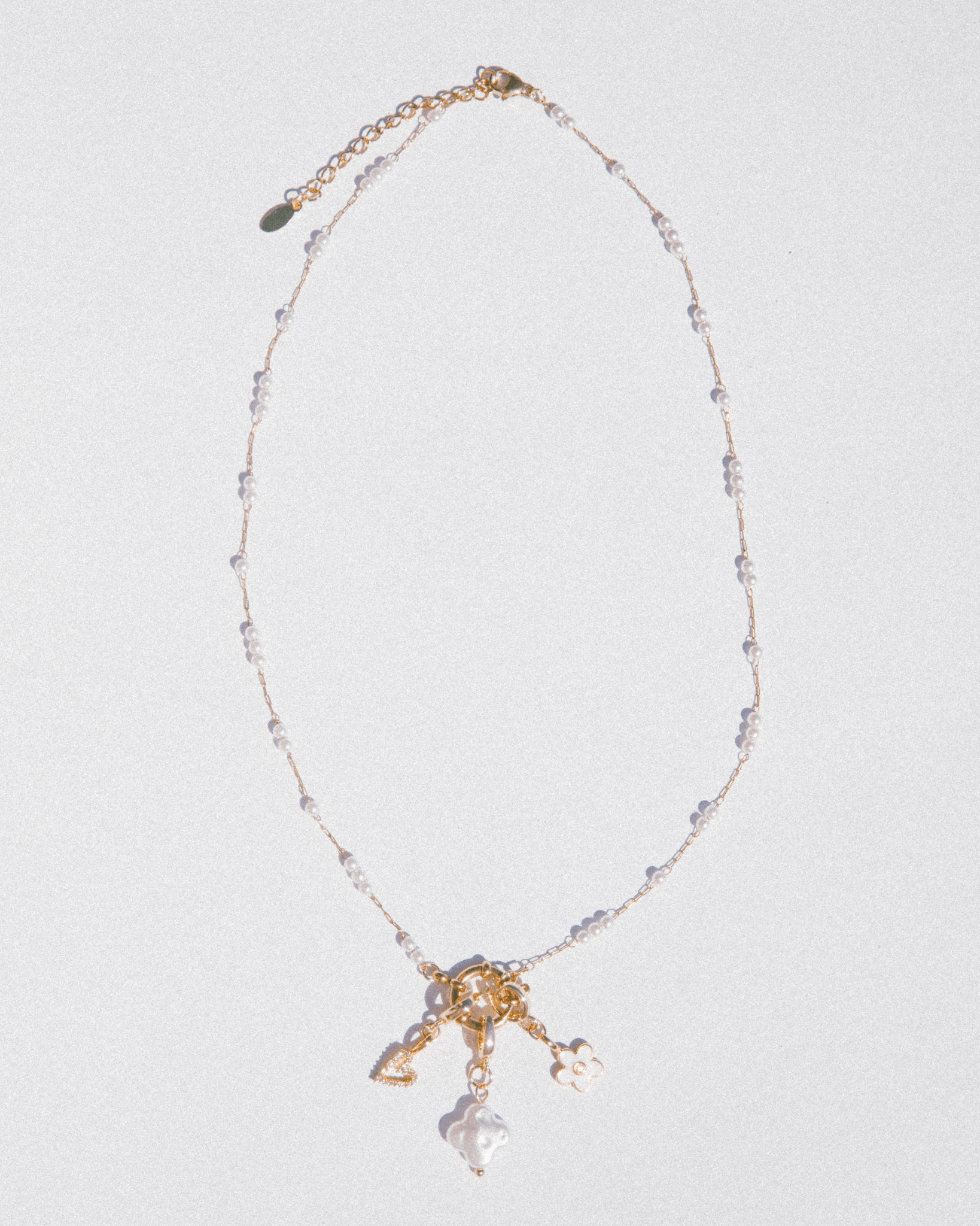Necklace with gold and crystal elements on a light gray background