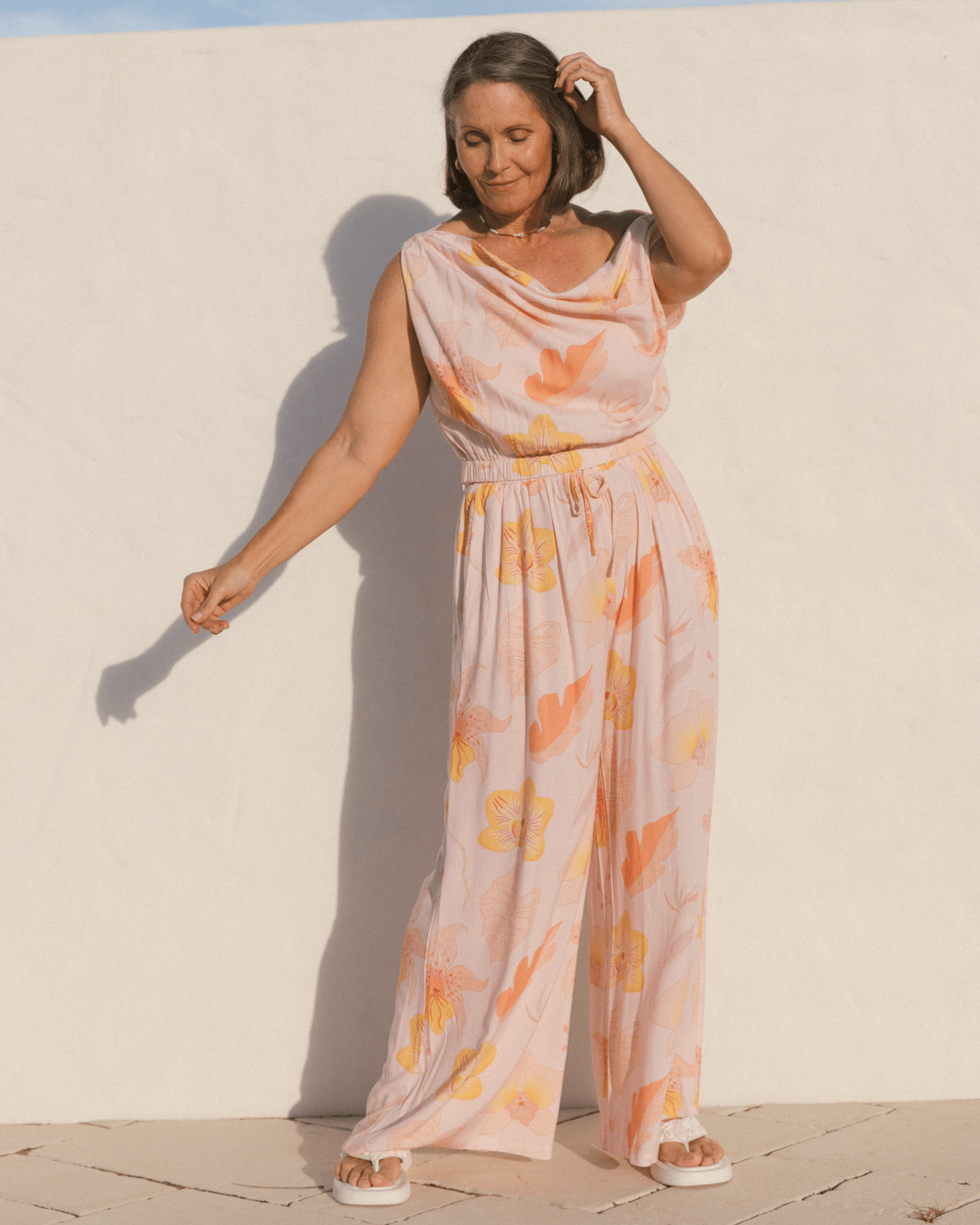 Woman wearing a floral breastfeeding friendly crop with a long flowy pants in a spring pattern.