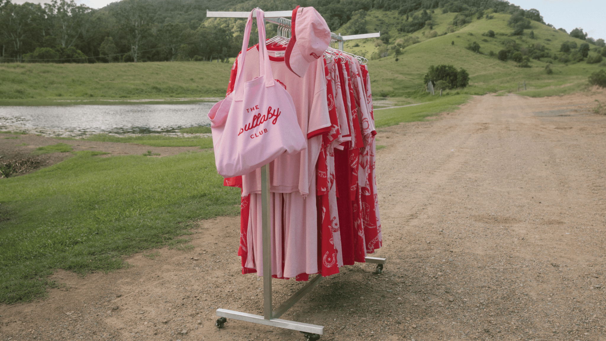Clothing rack showcasing Wild Hearts collection on a farm with Western-inspired fashion pieces, including bold Western prints, slouchy tees, and cowboy chic styles. Perfect for a Pinterest-girlie wardrobe with effortless, easy-to-style silhouettes for mum