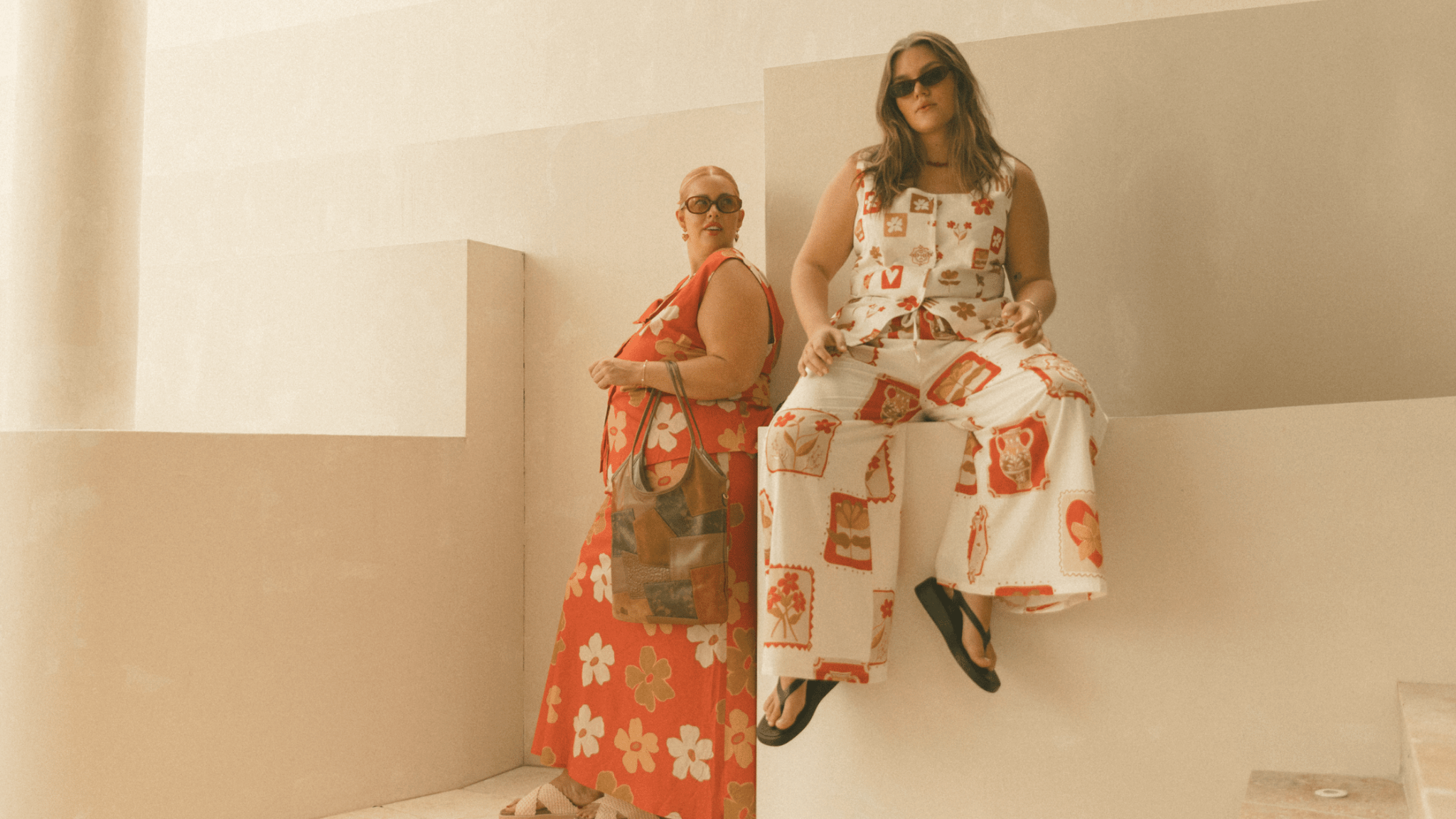 Three women wearing linen printed sets, relaxed sitting on stairs outside in a fashionable manner