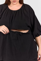 Close up of black peplum top with hidden breastfeeding zip. 