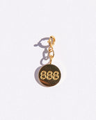 Gold circle charm with angel number '888' on a white background
