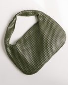 Green woven handbag on a white background