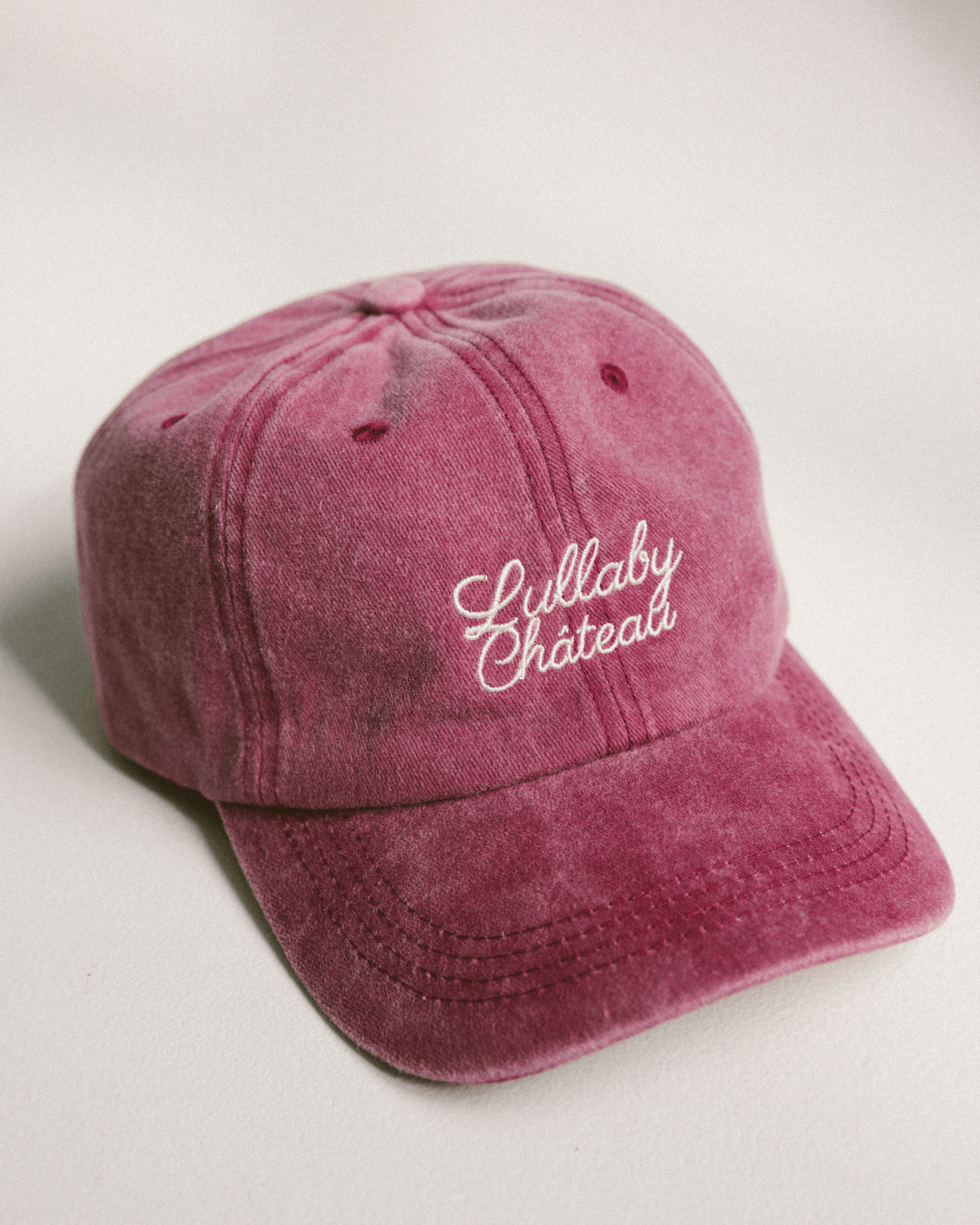 Distressed denim wine coloured cap with 'Lullaby Cháteau' embriodered in cursive font