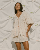 Woman wearing feminine set with tie-up top and pillow sleeves. 