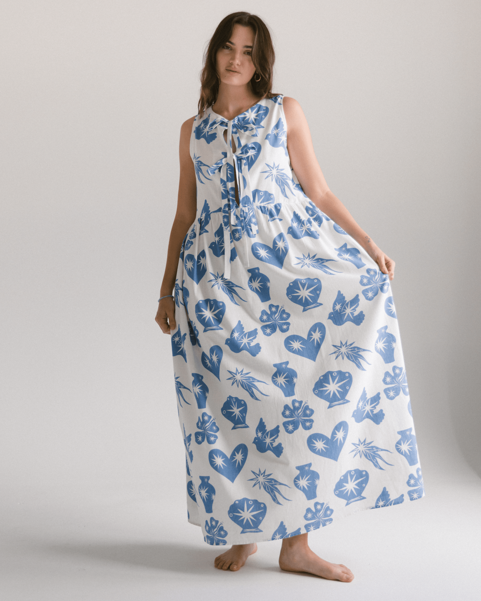 Woman wearing reversible maxi dress with front breastfeeding ties. Dress is in a white and blue star print. 