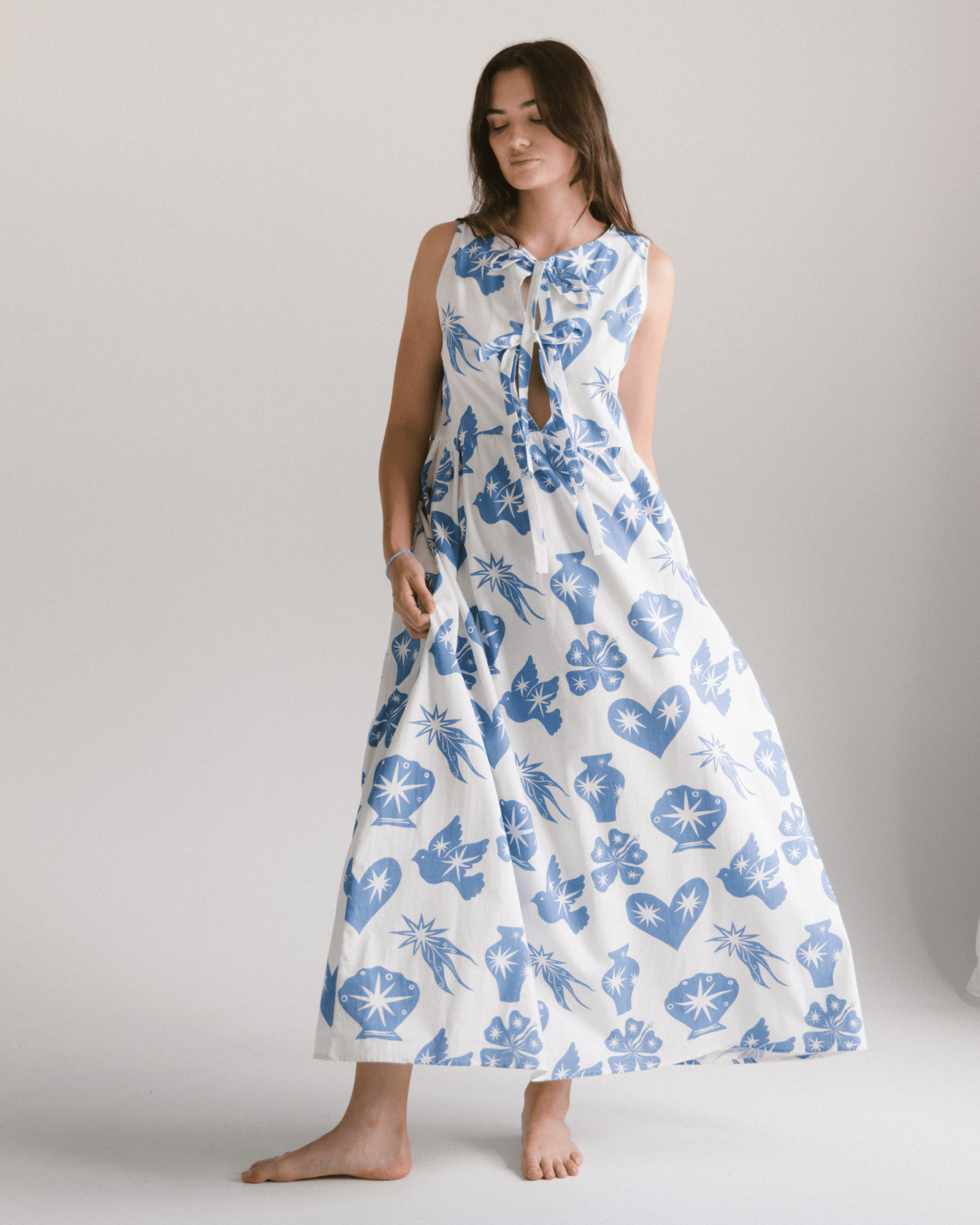 Woman wearing a long blue and white star pattern dress in an oversized design. 