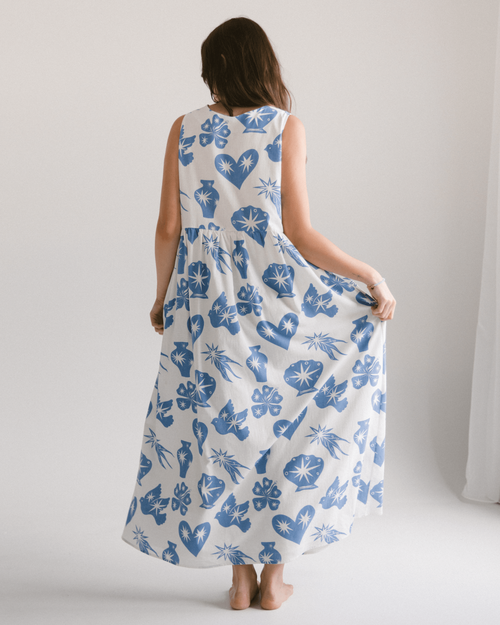 Woman wearing flowy and breathable maxi dress in a blue and white star print. 