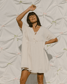 Woman wearing oversized smock style dress in a cream crepe fabric. 