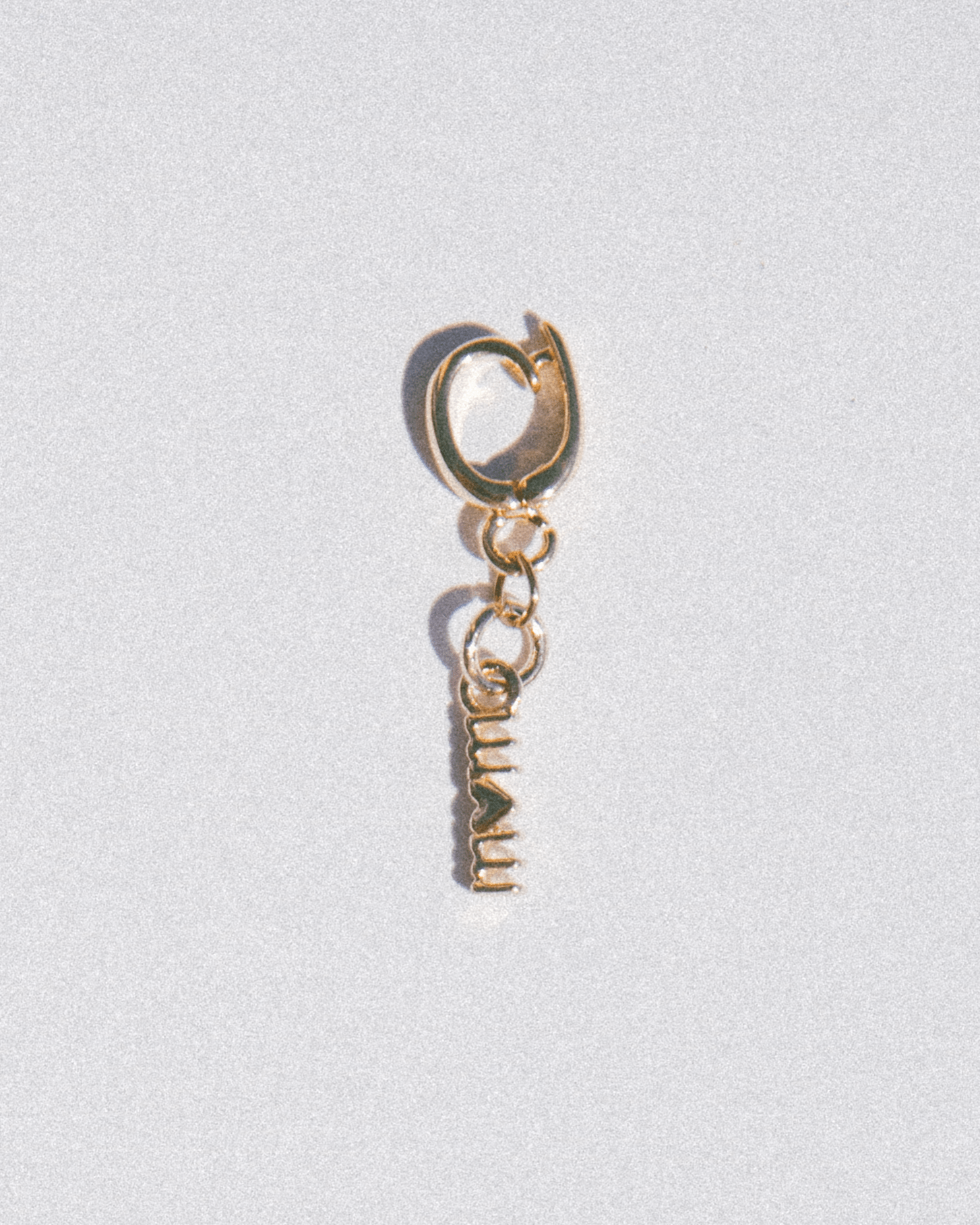 Gold 'mom' charm with a heart replacing the O. 