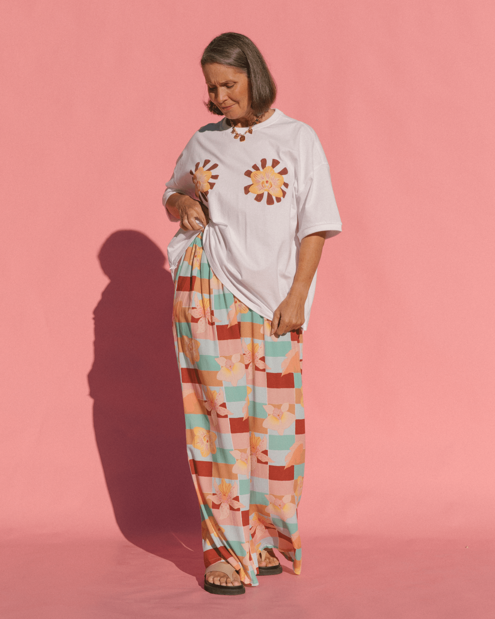 Woman wearing wide legged long pants in a spring print. 