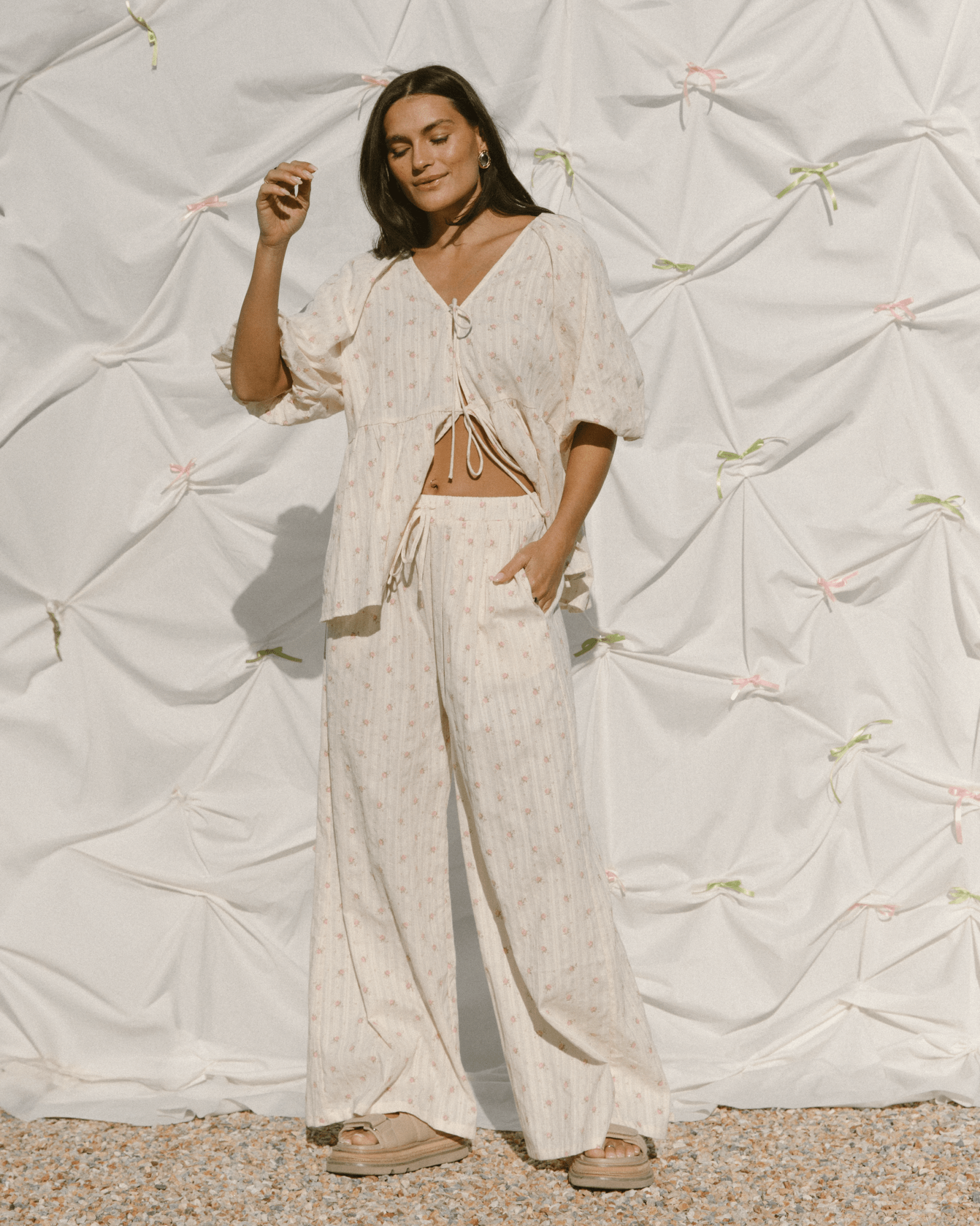 Woman wearing cream coloured set with pink floral pattern. 