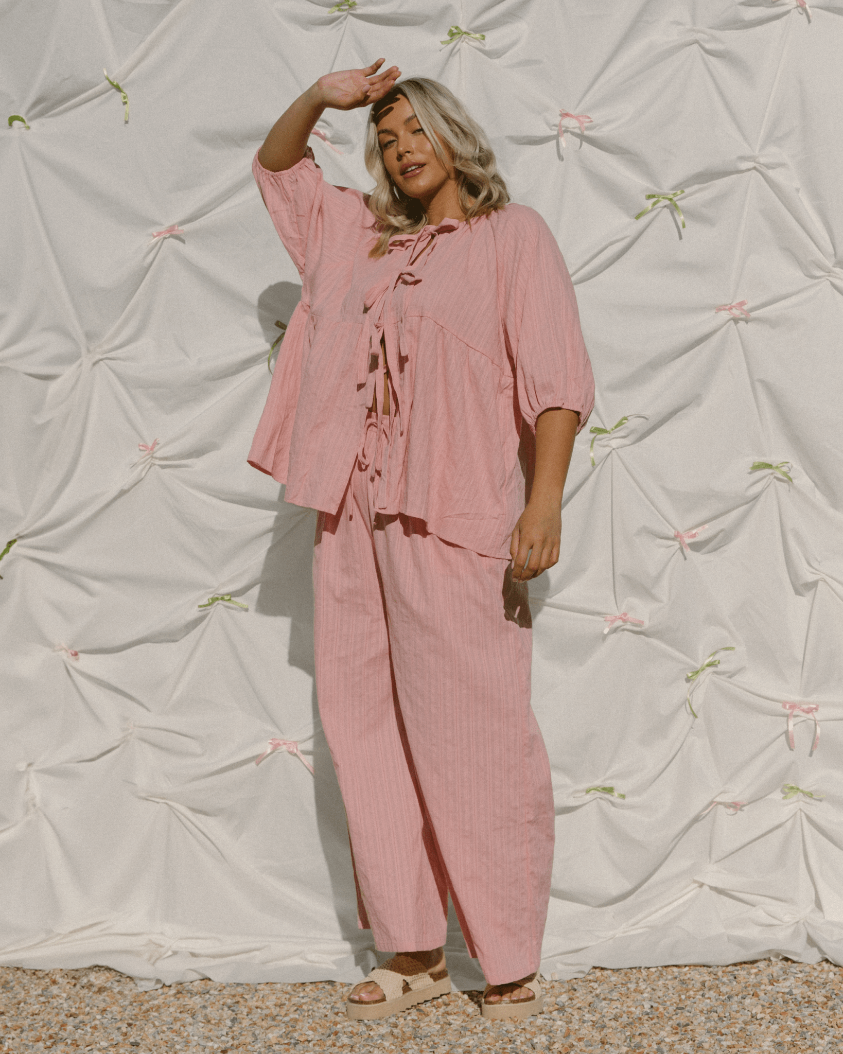 Woman wearing a stylish blush pink lounge set with reversible top. 