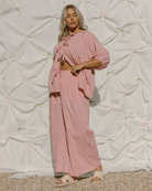 Woman wearing a pink stylish outfit with pink bows. 