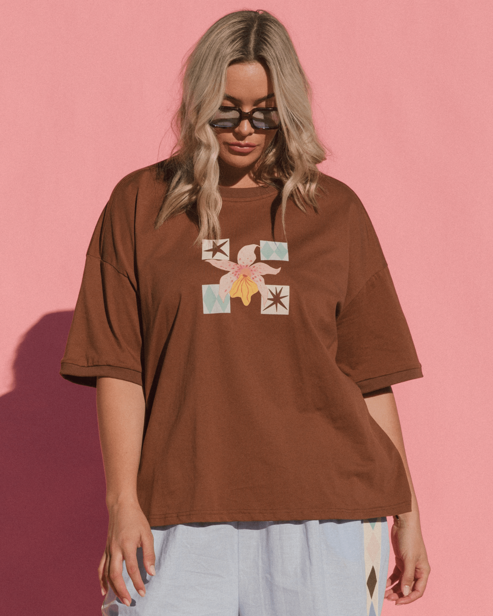 Woman wearing wide slouch fit graphic tee with drop shoulder in an orchid print. 