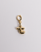 A gold-plated stainless steel charm in the shape of the letter T with a secure clasp for attachment to jewelry.