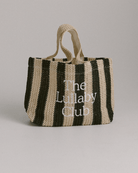 A black and natural raffia tote bag with 'The Lullaby Club' embroidered on the front.