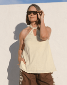 Women wearing stylish pale yellow halter top with a pink bead around the neckline. 